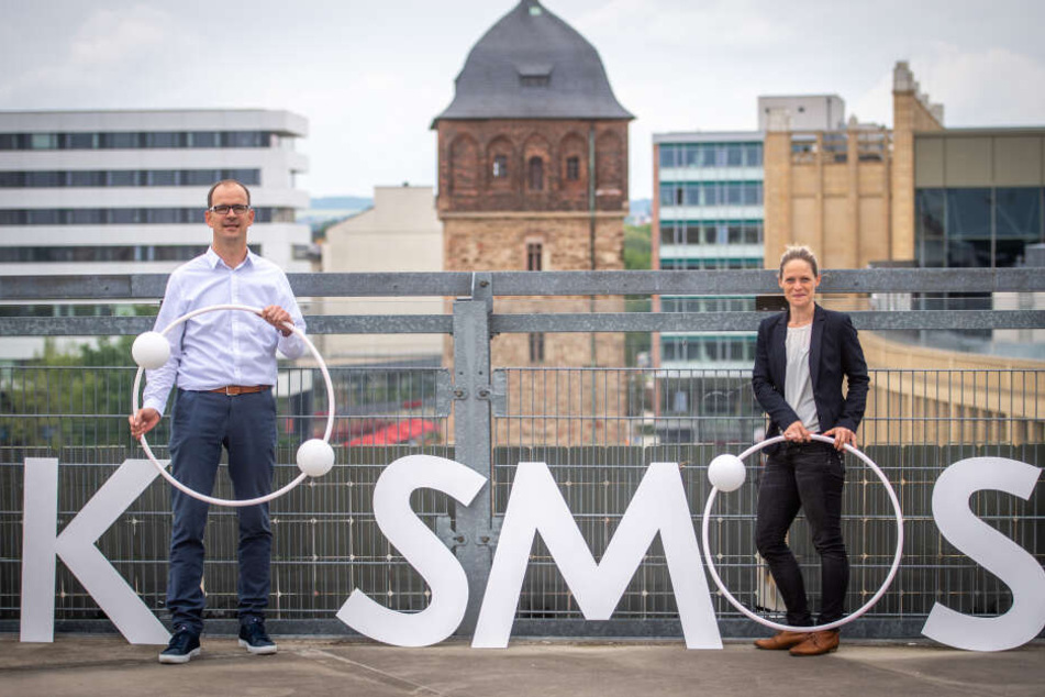 CWE-Chef Sören Uhle (44) und CWE-Marketing-Chefin Susan Endler (37) mit dem Logo des "KOSMOS CHEMNITZ" vor dem Roten Turm.