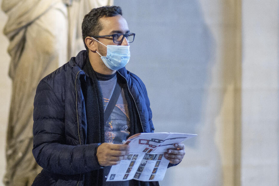 Ein Mann mit einer Schutzmaske besucht das Kunstmuseum Louvre.