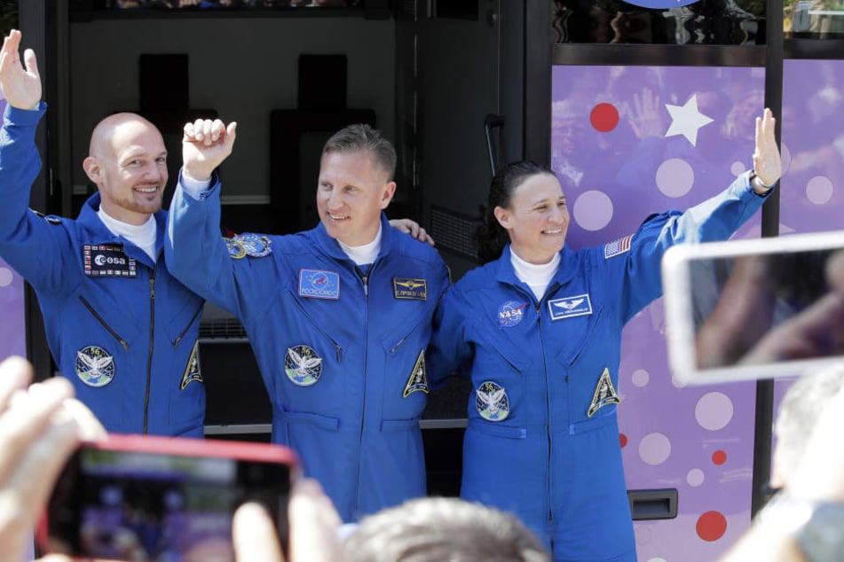 Der deutsche Astronaut Alexander Gerst (l-r), der russische Kosmonaut Sergej Prokopjew und die US-amerikanische Astronautin Serena Aunon-Chancellor winken vor ihrer Abfahrt mit einem Bus vom Hotel zum Kosmodrom.