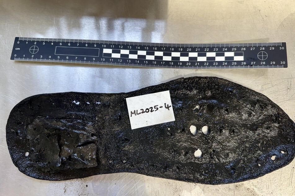 A handout photo released by The Vindolanda Trust in London shows a section of a large leather shoe, one of 32 shoes uncovered so far, by the Trust during an excavation at Magna Roman Fort, near Greenhead, northeast England.