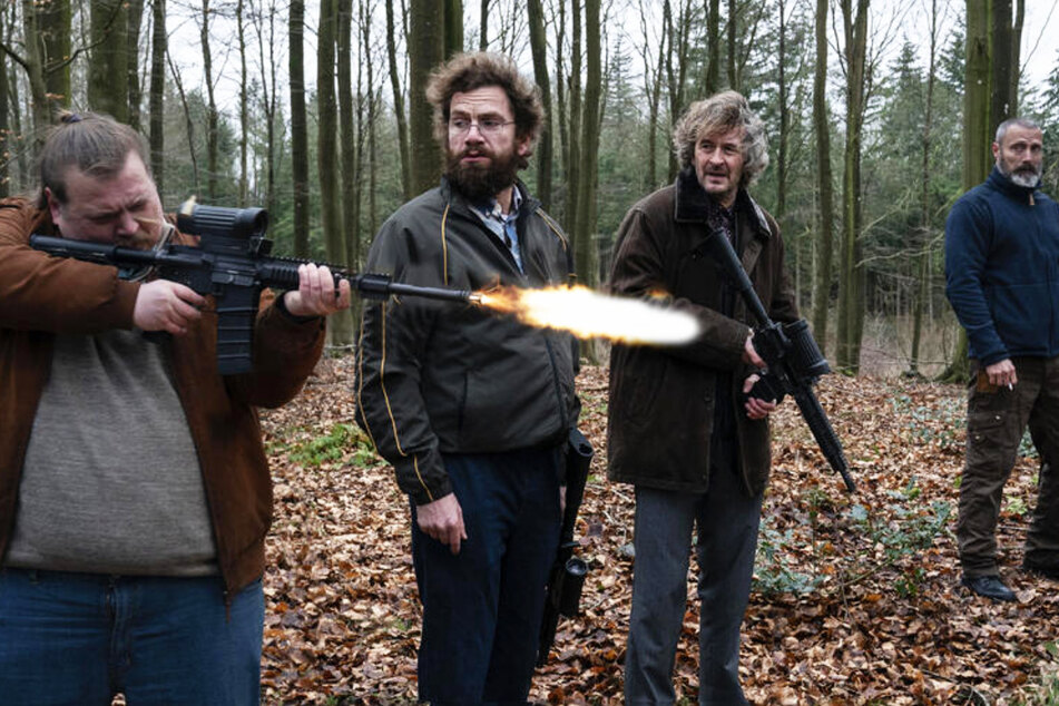 Markus (Mads Mikkelsen, 55, r.) bringt Emmenthaler (Thomas Bro, 49, l.), Otto (Nikolaj Lie Kaas, 48) und Lennart (Lars Brygmann, 64) das Schießen bei. Besonders Emmenthaler lernt schnell.