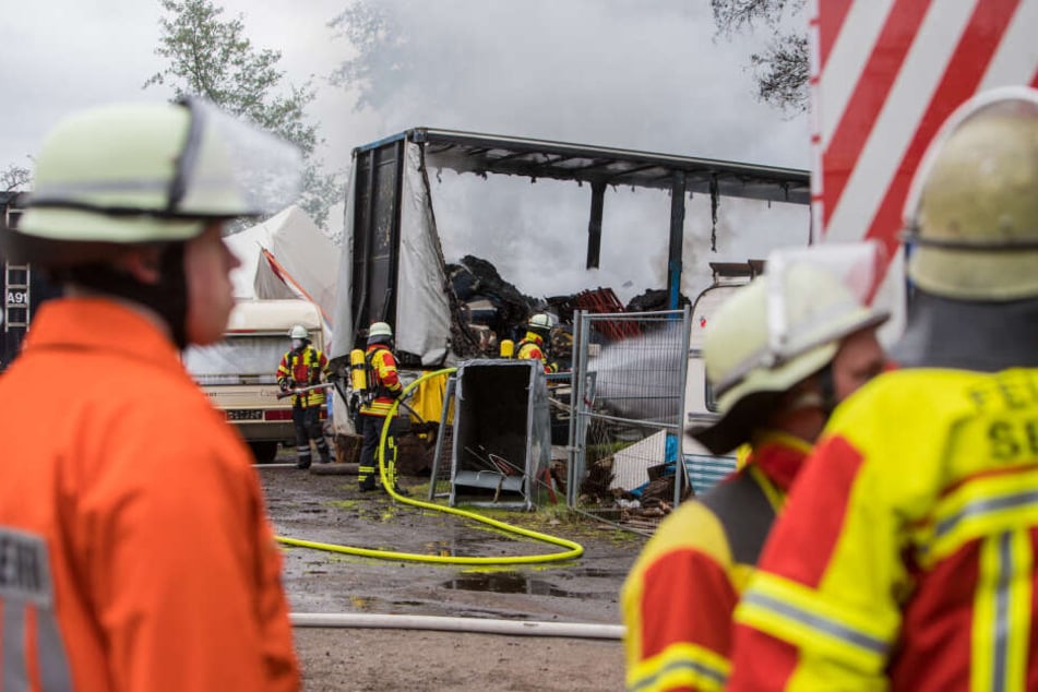 Feuerwehrleute stehen vor einem betroffenen Wohnwagen.