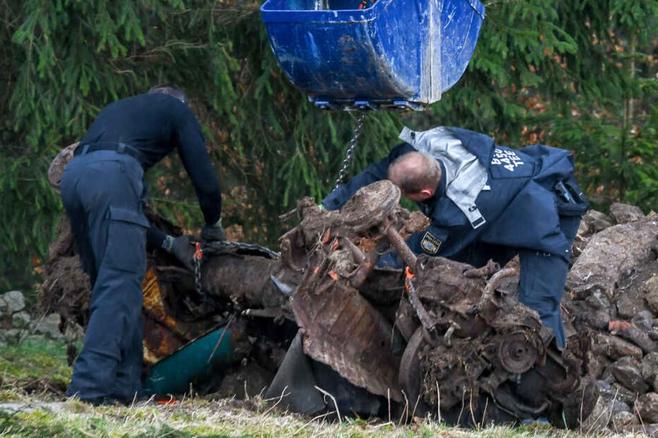 Einsatzkräfte der Polizei heben mit einem Kran ein Auto aus einem möglichen Ablageort einer Mädchenleiche.