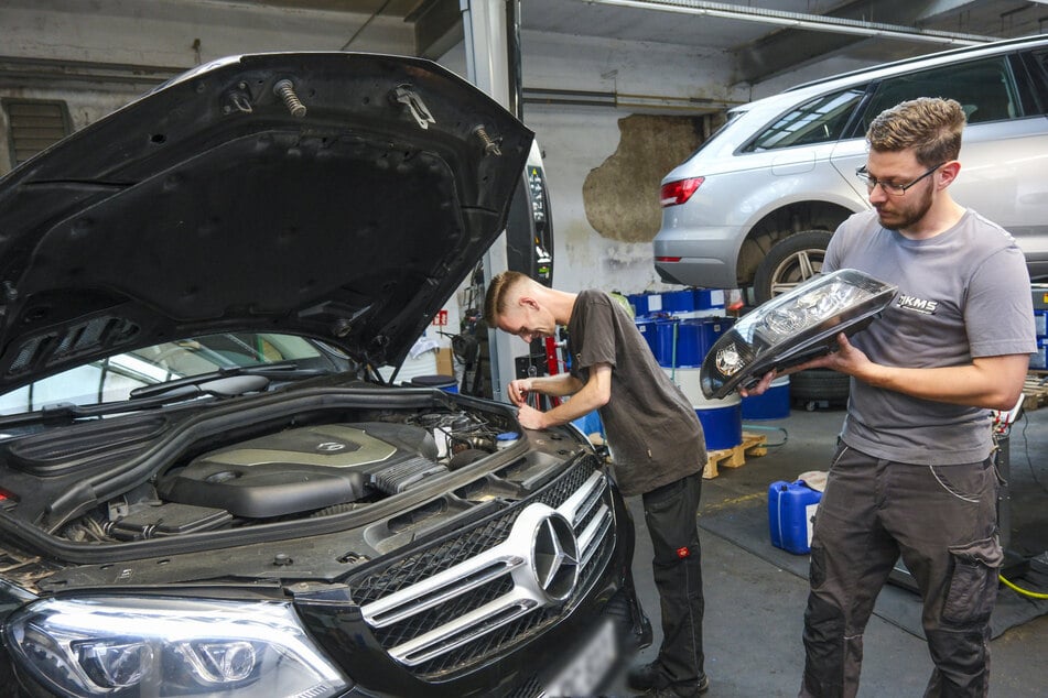 Richard Stöver (26, l.) und Dominik Knoll inspizieren Autoteile.
