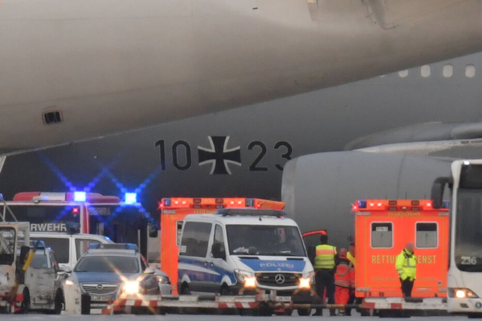 Rettungskräfte und Polizisten stehen an dem Flugzeug.