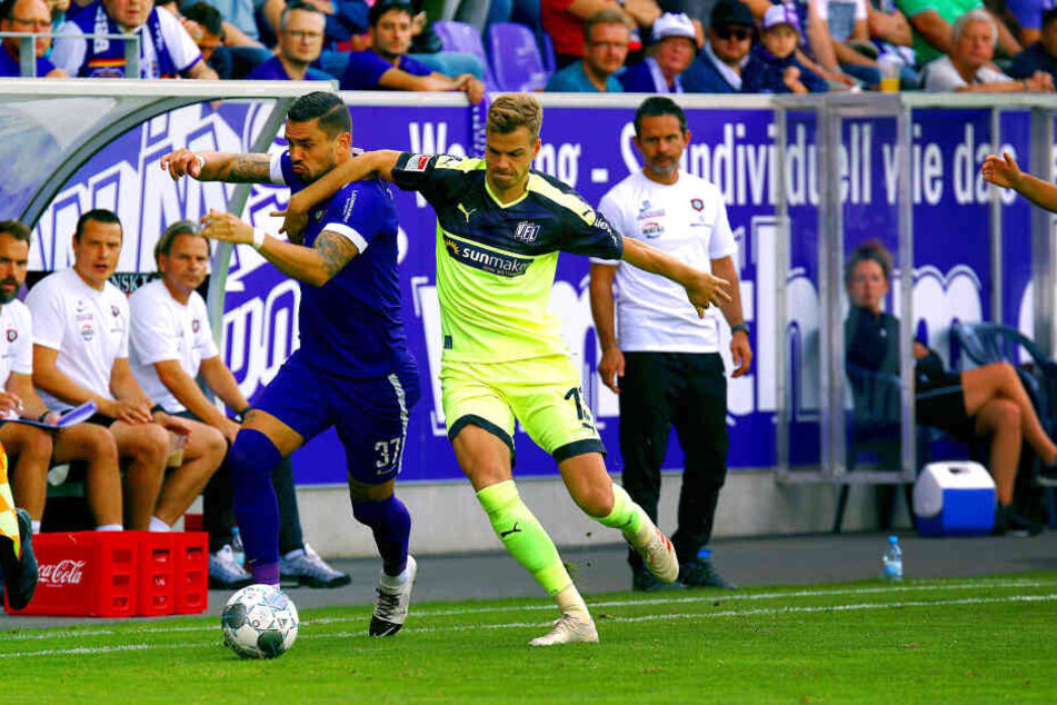 Pascal Testroet (l.) setzt sich energisch gegen Onsabrücks Joost van Aken durch - Aues Trainer Dirk Schuster (r.) hat die Aktion genau im Blick.