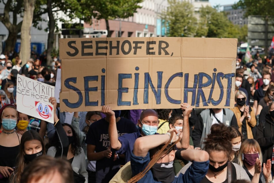 Teilnehmer einer Demonstration eines Bündnisses für die sofortige Evakuierung aller griechischen Lager halten ein Schild mit der Aufschrift "Seehofer, sei ein Christ".