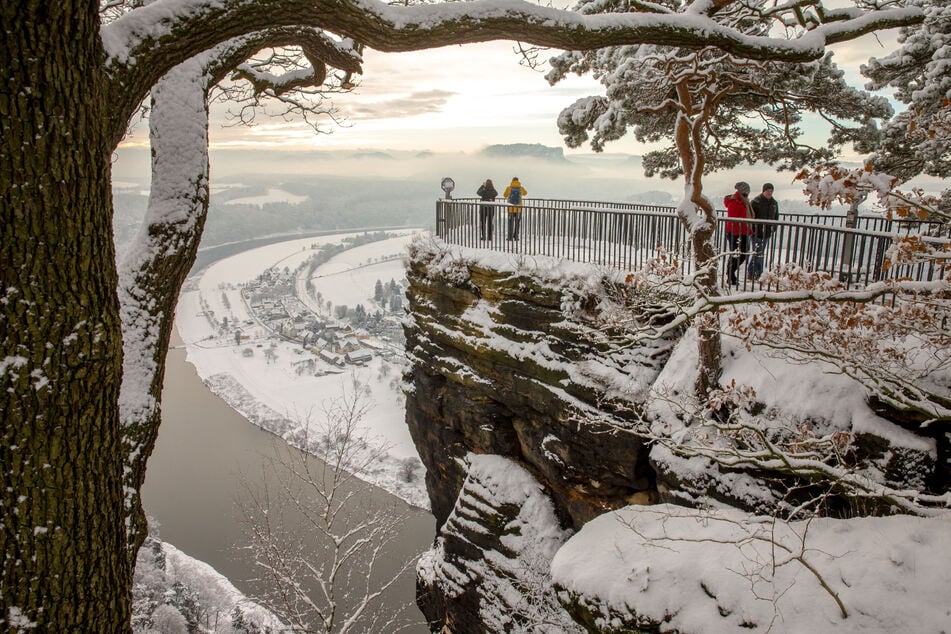 Das Elbsandsteingebirge - ein Wintermärchen. Touristen bewundern es auf der Bastei-Aussicht.
