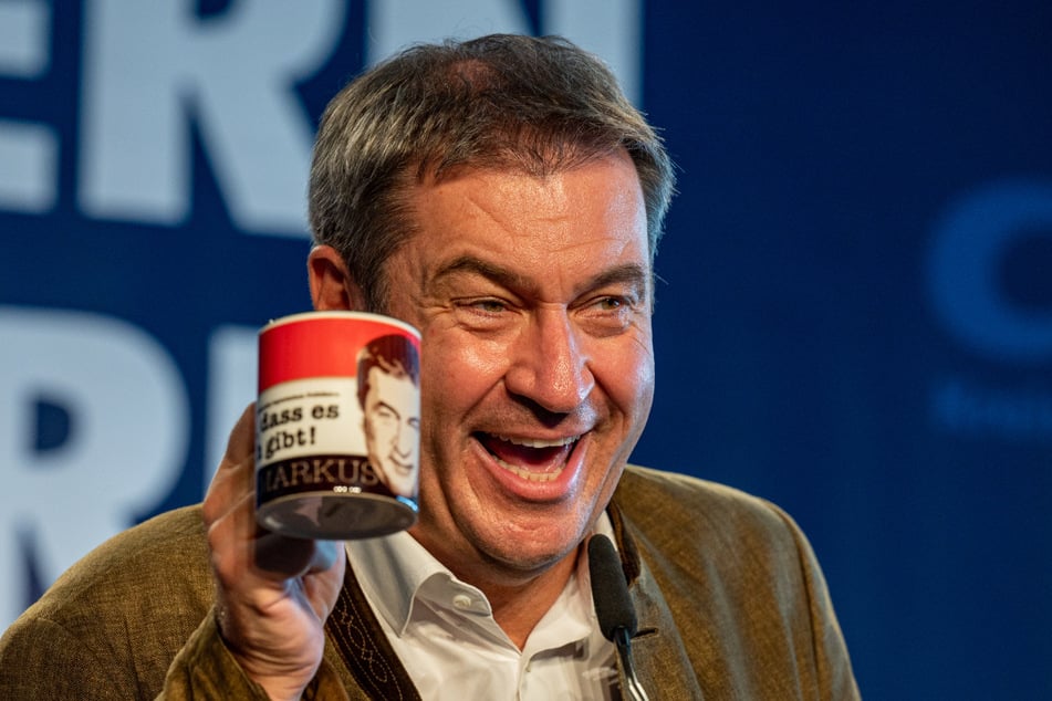 Markus Söder freut sich beim Politischen Frühschoppen Gillamoos über eine Tasse mit der Aufschrift "Schön dass es mich gibt! Markus".