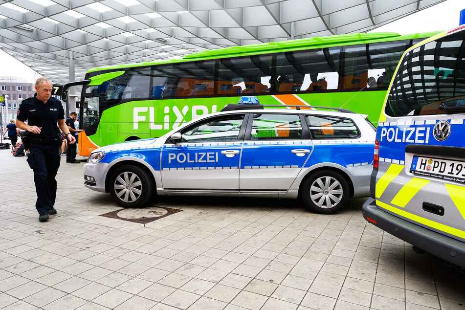 Polizeiautos stehen neben einem Reisebus des Anbieters Flixbus. (Symbolbild)