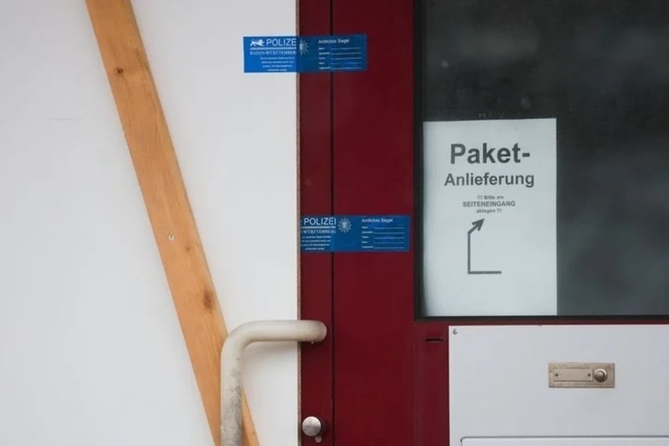 Polizei-Siegel sind an der Eingangstür einer Firma zu sehen.