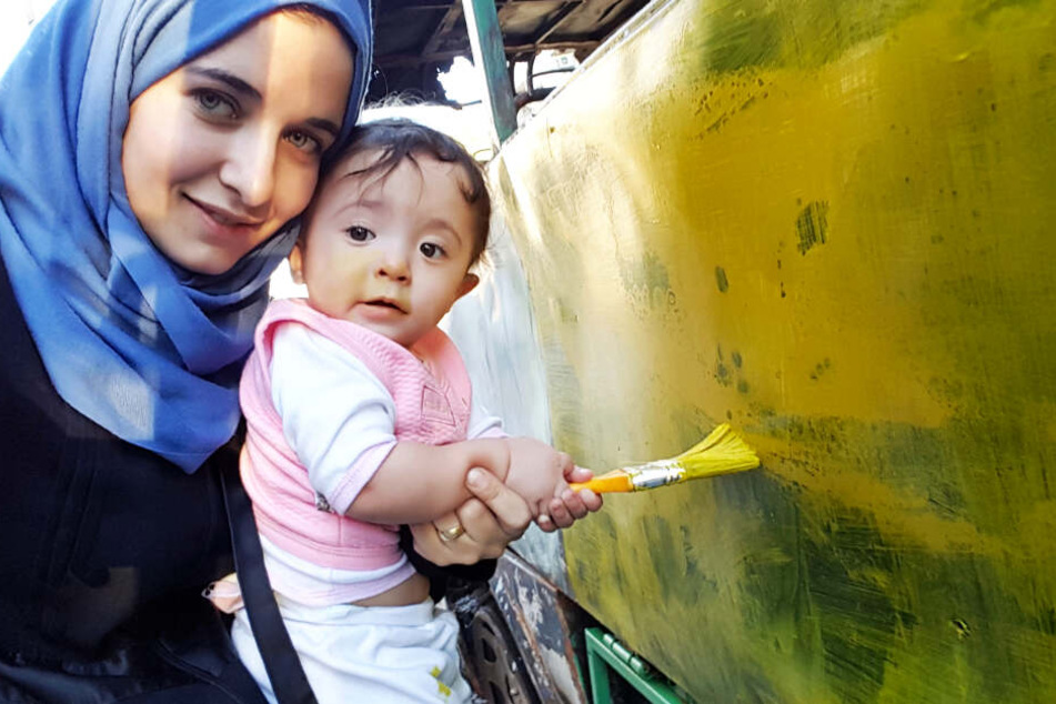 Den Kriegsalltag durchbrechen die Menschen immer wieder mit schönen Szenen. Hier malt Waad Al-Kateab mit ihrer Tochter Sama einen Bus an.