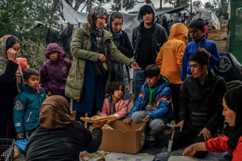 Migranten warten darauf in einem Zwischenlager neben dem Lager Moria auf der Insel Lesbos Brot zu kaufen.