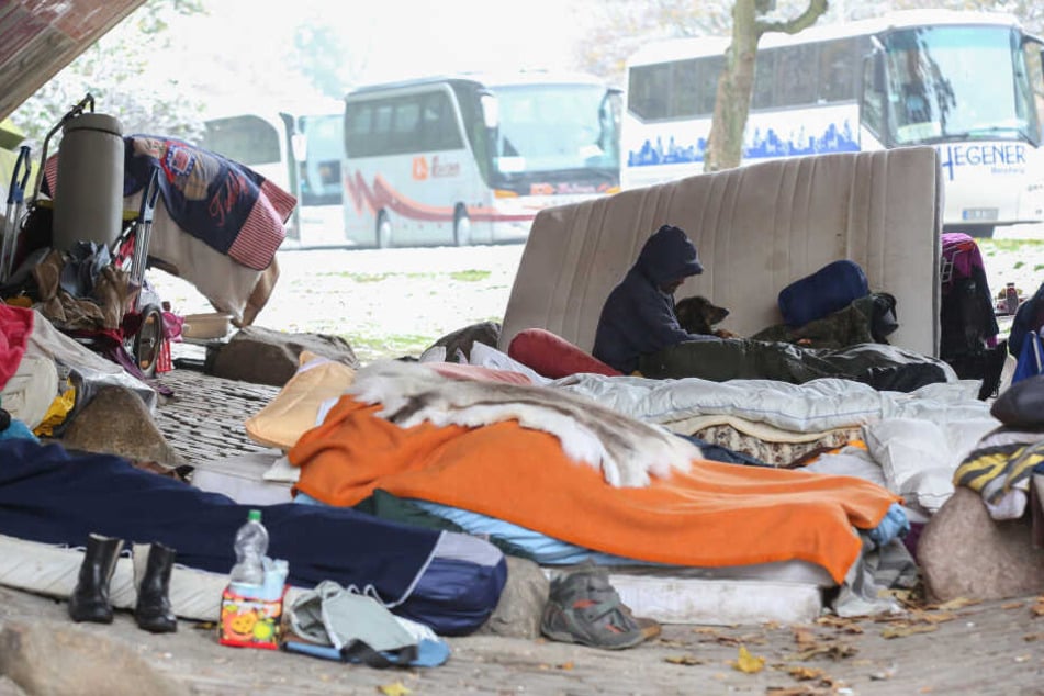 Obdachlose sitzen bei Temperaturen um den Gefrierpunkt zwischen Decken und Matratzen unter einer Brücke an der Helgoländer Allee.