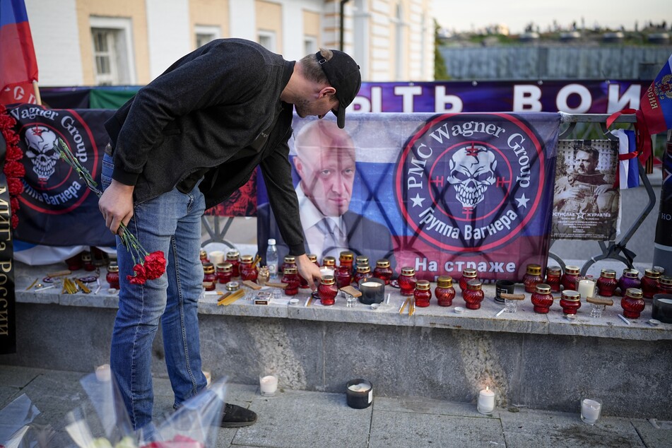 Ein Mann stellt eine Kerze an die Gedenkstätte für Jewgeni Prigoschin in Moskau.