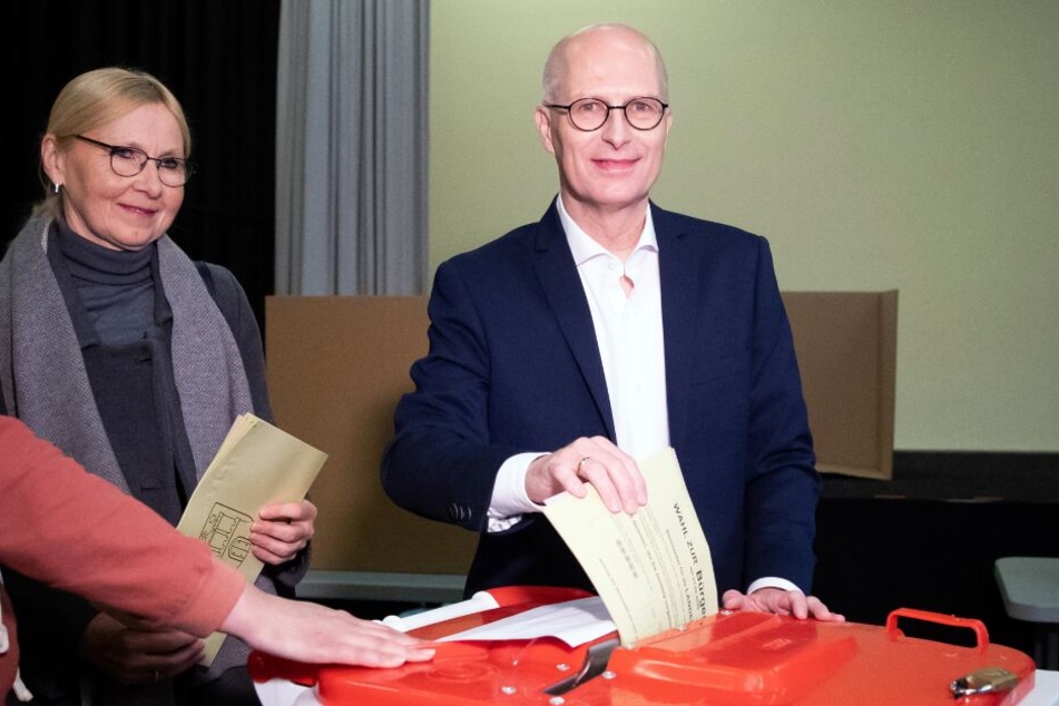 Peter Tschentscher (SPD) und seine Ehefrau Eva-Maria (l) geben in einem Wahllokal ihre Stimme für die Bürgerschaftswahl ab.