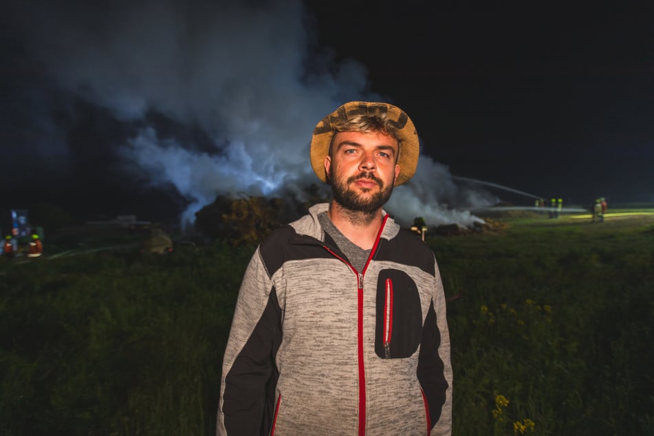 Landwirt Marcel Schaller steht vor seinen brennenden Strohballen. Auf den Landwirt bzw. seine Fahrzeuge sollen laut eigener Aussage in den vergangenen Wochen mehrere Anschläge verübt worden sein. Im jüngsten Fall brannte eine Scheune vollständig ab.