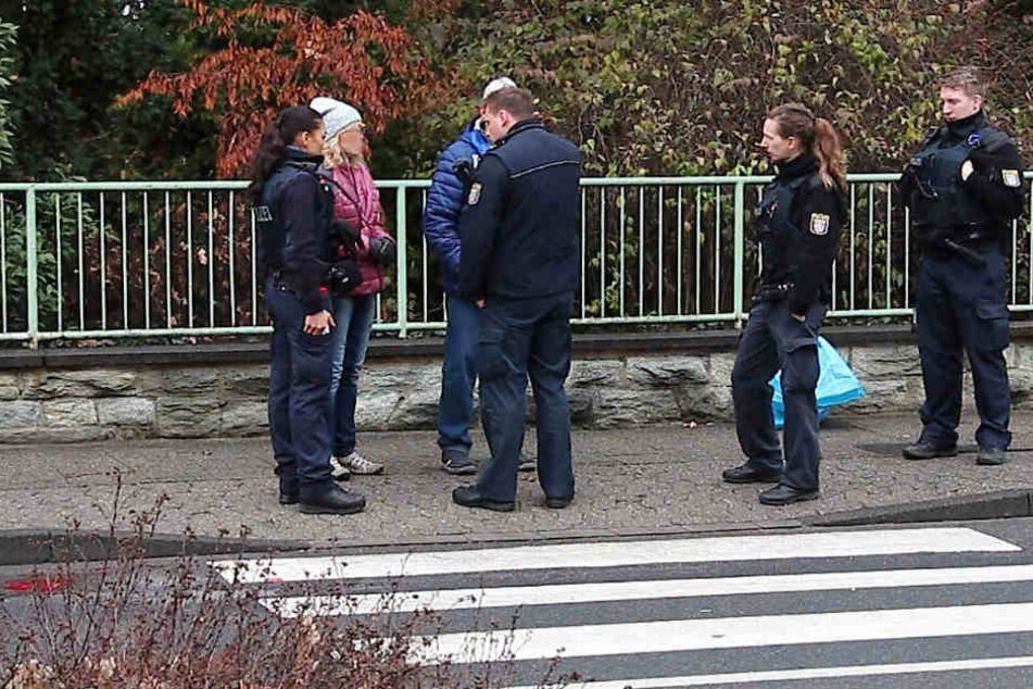 Polizisten befragen mögliche Augenzeugen des Unfalls.