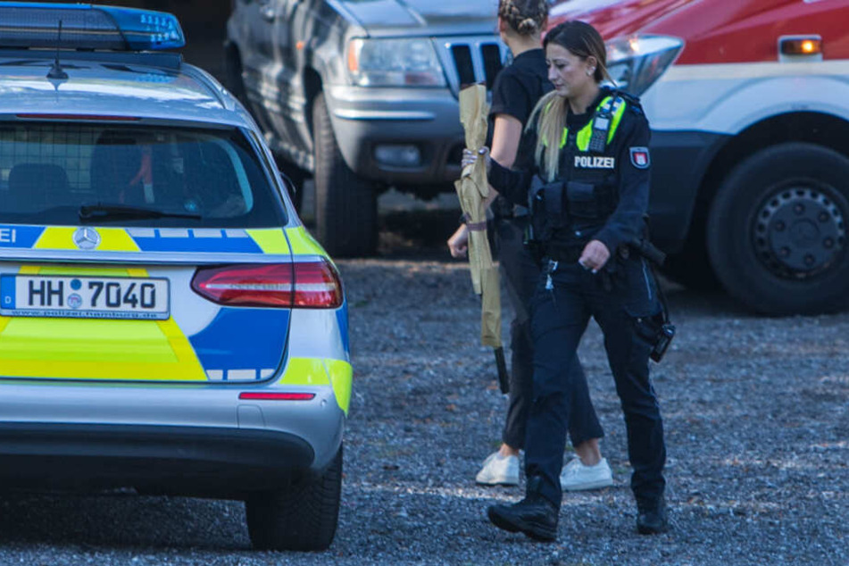 Eine Polizisten stellt das Gewehr des Mannes sicher.