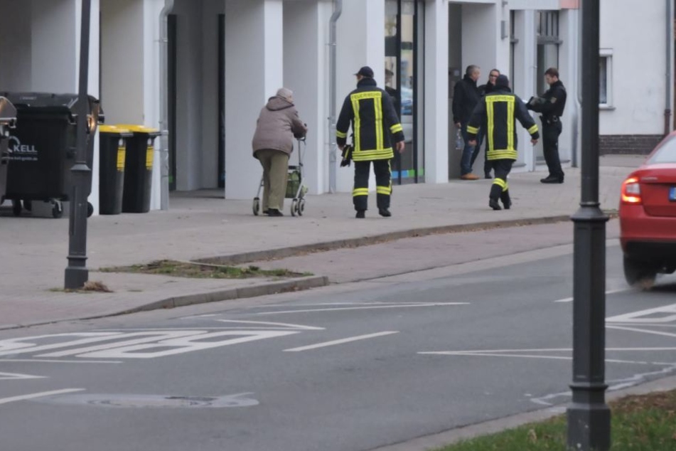 Ein Polizeibeamter ist einer älteren Dame beim Verlassen ihrer Wohnung behilflich.