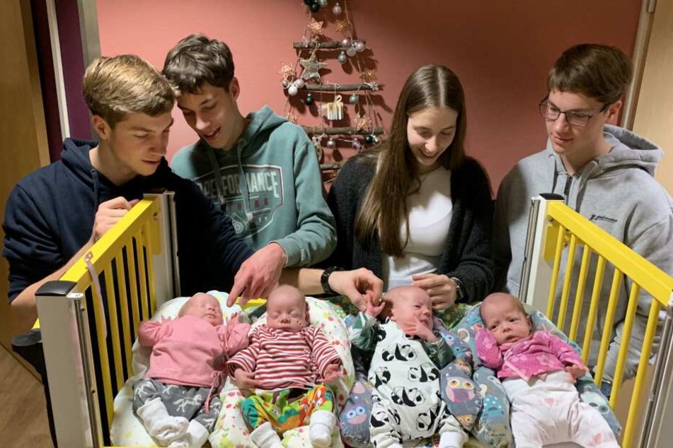 Die 18-jährigen Vierlinge (hinten l-r) Thomas, David, Laura und Florian, schauen sich die kleinen Vierlinge (l-r) Ina, Hanna, Noah und Finja an.