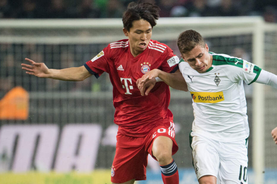 Woo-yeong Jeong im Zweikampf mit Thorgan Hazard (r).
