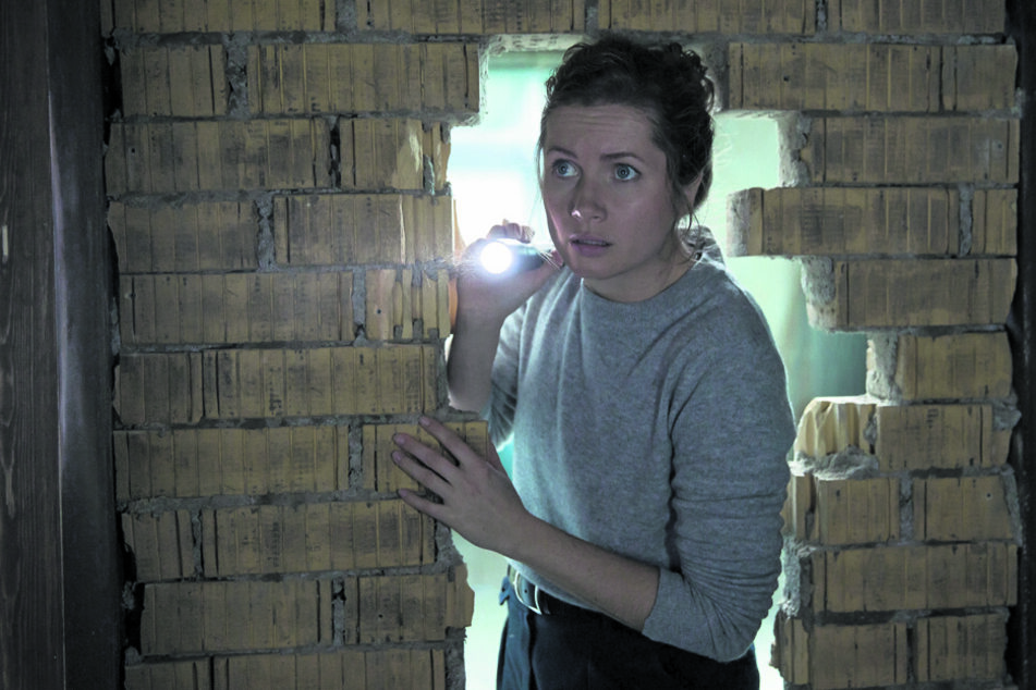 Leonie Winkler (Cornelia Gröschel) leuchtet mit einer Taschenlampe in den dunklen Raum hinter der Mauer.