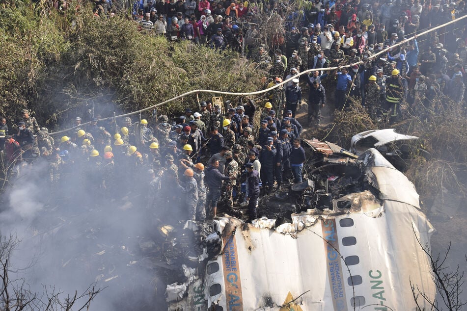 Nepalesische Rettungskräfte arbeiten an dem Wrack des abgestürzten Passagierflugzeugs.
