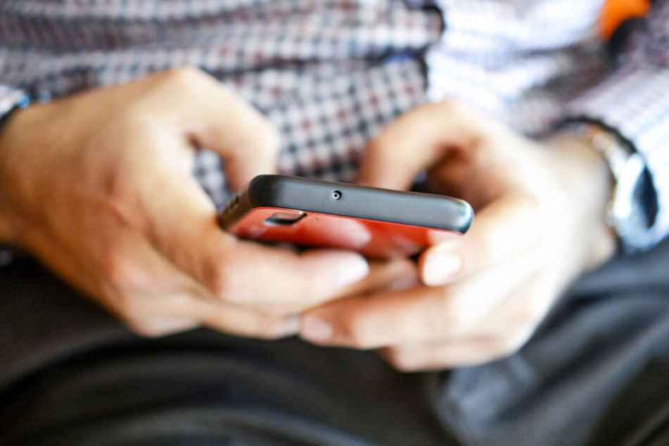 Ein Mann schreibt eine Nachricht auf seinem Smartphone (Symbolbild).