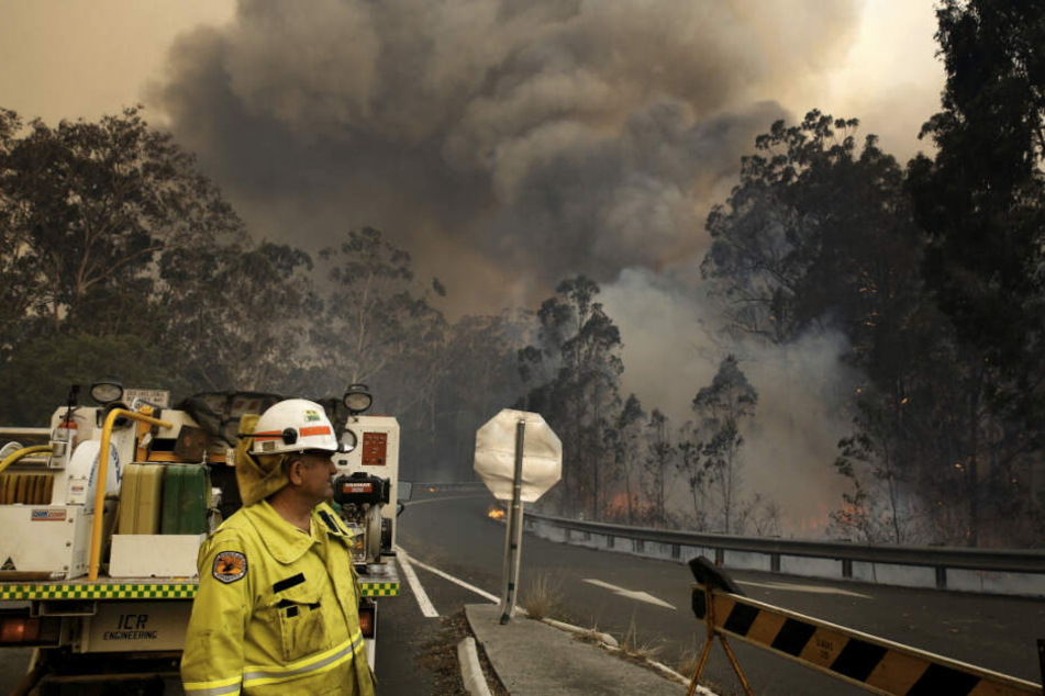 Eine Crew des Nationalparks zieht sich zu einer Straßensperre zurück, während das Hillville-Feuer entlang des Bullocky Way brennt.