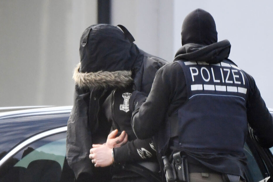 Ein Tatverdächtiger wird von Polizisten abgeführt. Er soll Mitglied einer mutmaßlichen Nazi-Terror-Gruppe sein. (Archivbild)