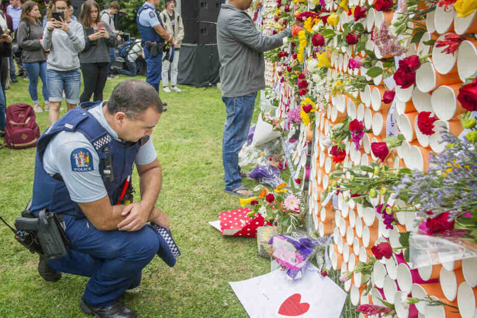 Ein Polizist vor dem behelfsmäßigen Denkmal für die Opfer der Anschläge von Christchurch an der University of Canterbury.