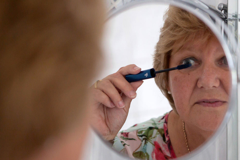 Eine Frau tuscht sich mit Mascara die Wimpern. (Symbolbild)