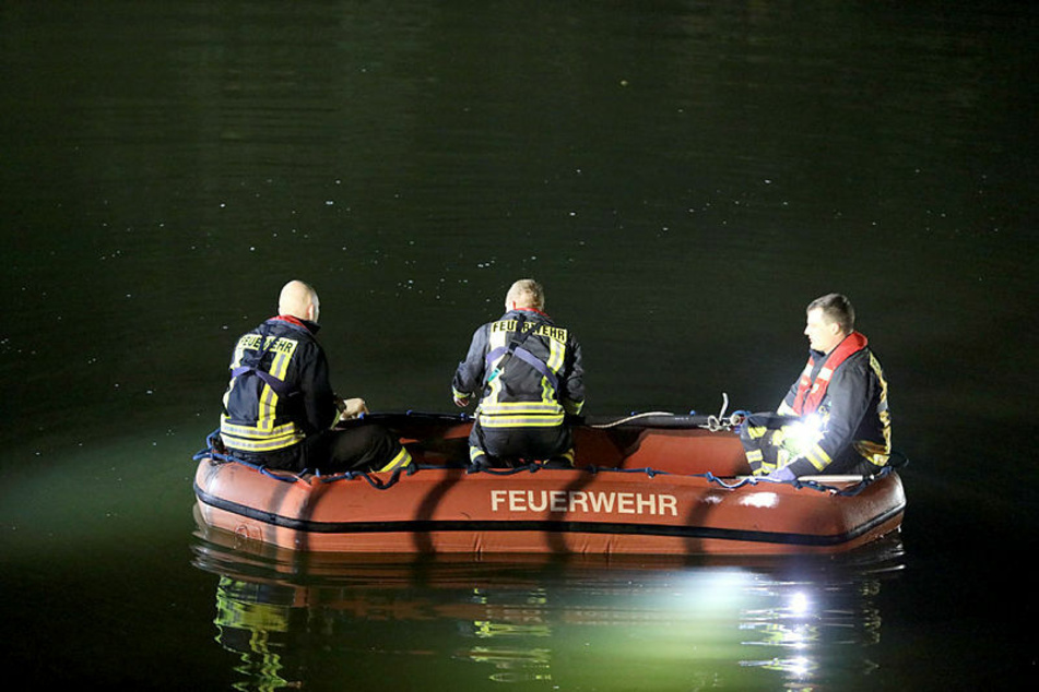 Feuerwehrleute suchen im Licht von Scheinwerfern im Elsterflutbett nach dem von der Brücke gestürzten Mann.