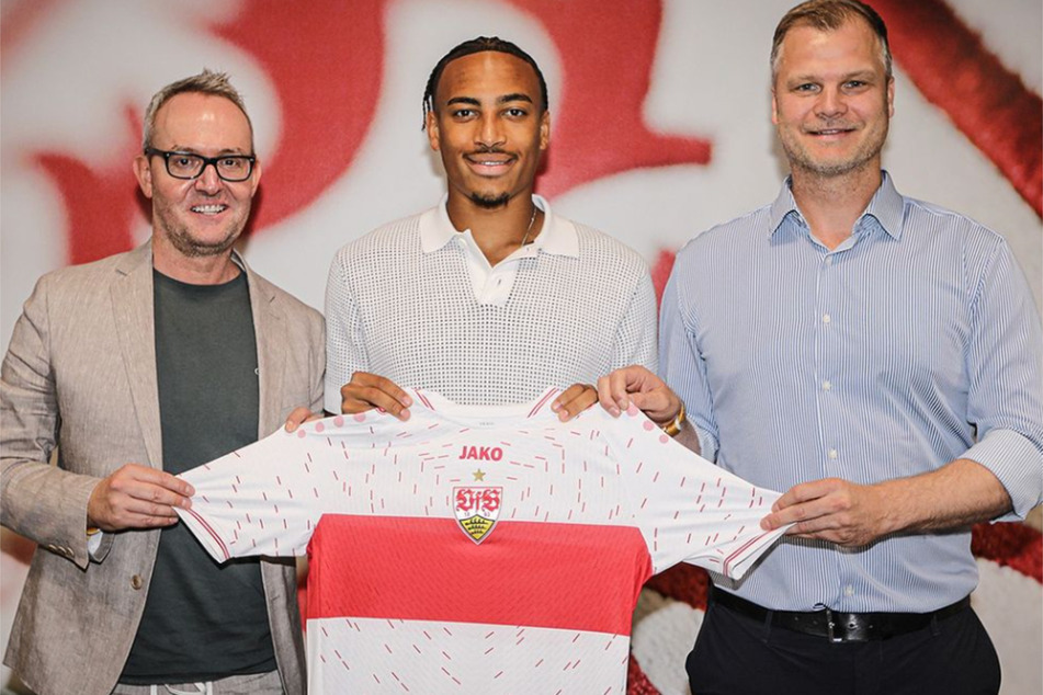 VfB-Neuzugang Jamie Leweling (22) präsentiert sein neues Trikot zusammen mit Sportdirektor Fabian Wohlgemuth (44, r.) und Alexander Wehrle (48, l.).
