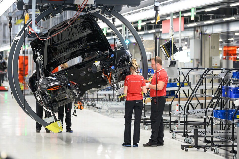 Mitarbeiter arbeiten während einer Showproduktion zur Eröffnung der Produktion des Porsche Taycan in Stuttgart.