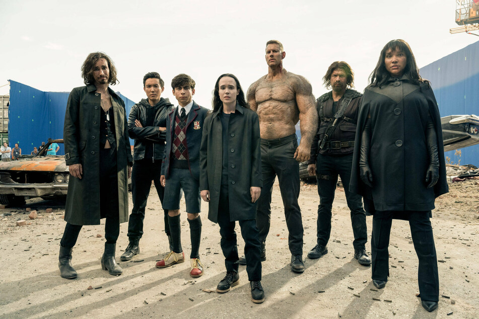 Elliot Page (m.) with costars on The Netflix Academy (from l to r): Aidan Gallagher, Justin H. Lin, Robert Sheehan, Tom Hopper, David Casta Eda, and Emmy Raver-Lampan.