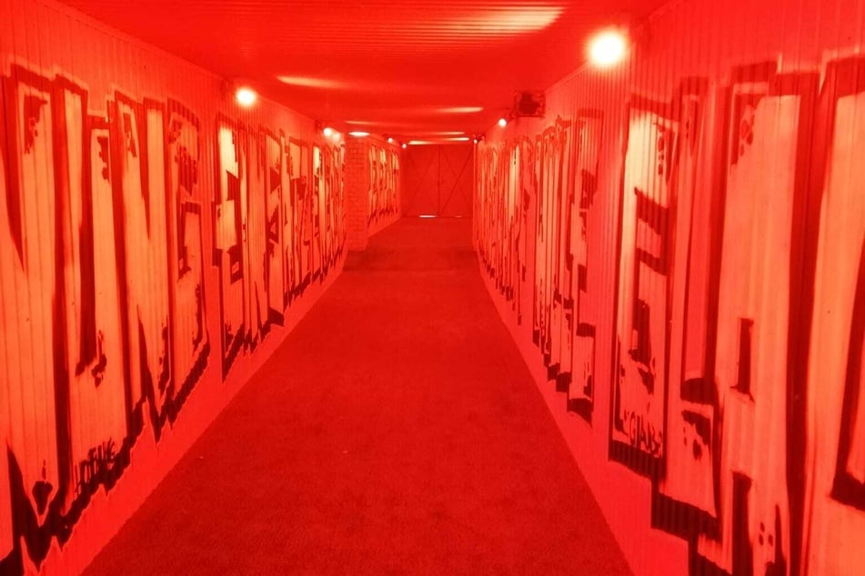 Der Spielertunnel in feurig-roten Tönen getaucht, jetzt aus Platzrichtung kommend.