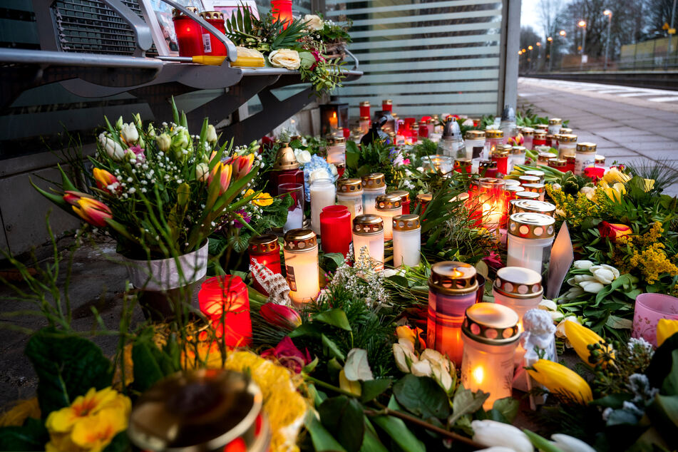 Kerzen und Blumen liegen am Bahnhof Brokstedt. Bei einer Messerattacke in einem Regionalzug waren am 25. Januar zwei Menschen getötet und fünf verletzt worden.