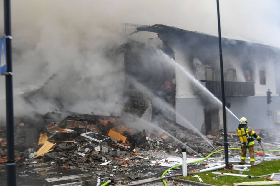 Ein Feuerwehrmann löscht den entstandenen Brand nach der Explosion.