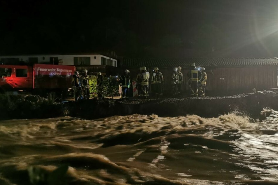 Feuerwehrleute sichern in der Nacht von Sonntag auf Montag einen Damm an der Rottach zwischen Rottach-Egern und Tegernsee. Durch den starken Regen seit Sonntagnachmittag führte die Rottach kurzfristig mehr Wasser.