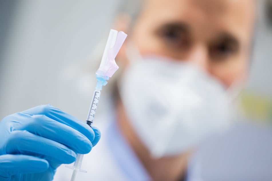 Ein Arzt hält eine Spritze, die den Impfstoff von Moderna gegen Covid-19 enthält, unmittelbar vor einer Impfung im Universitätsklinikum Essen.
