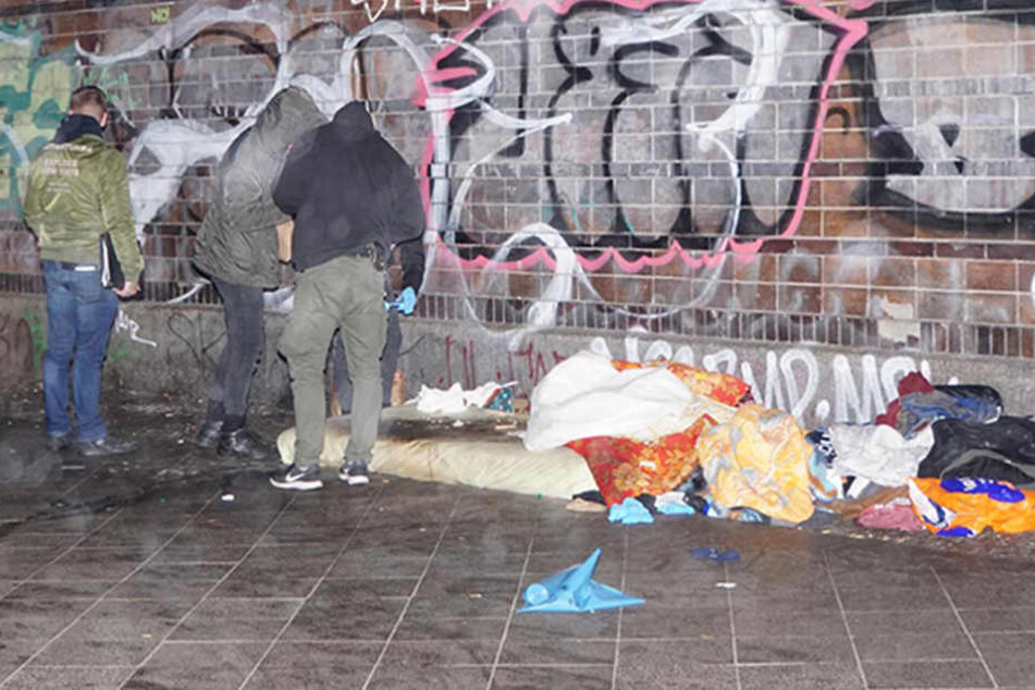 Beamte untersuchen den Schlafplatz des verstorbenen Mannes.