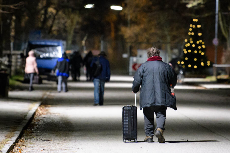 Obdachlose gehen über das Gelände der Bayernkaserne: Die Nachtunterkunft für Obdachlose wird während der Sprengarbeiten geräumt. (Archivbild)