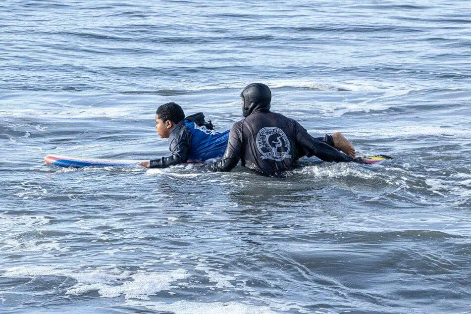 Lou Harris provides a free surfing lesson for kids at Rockaway Beach.