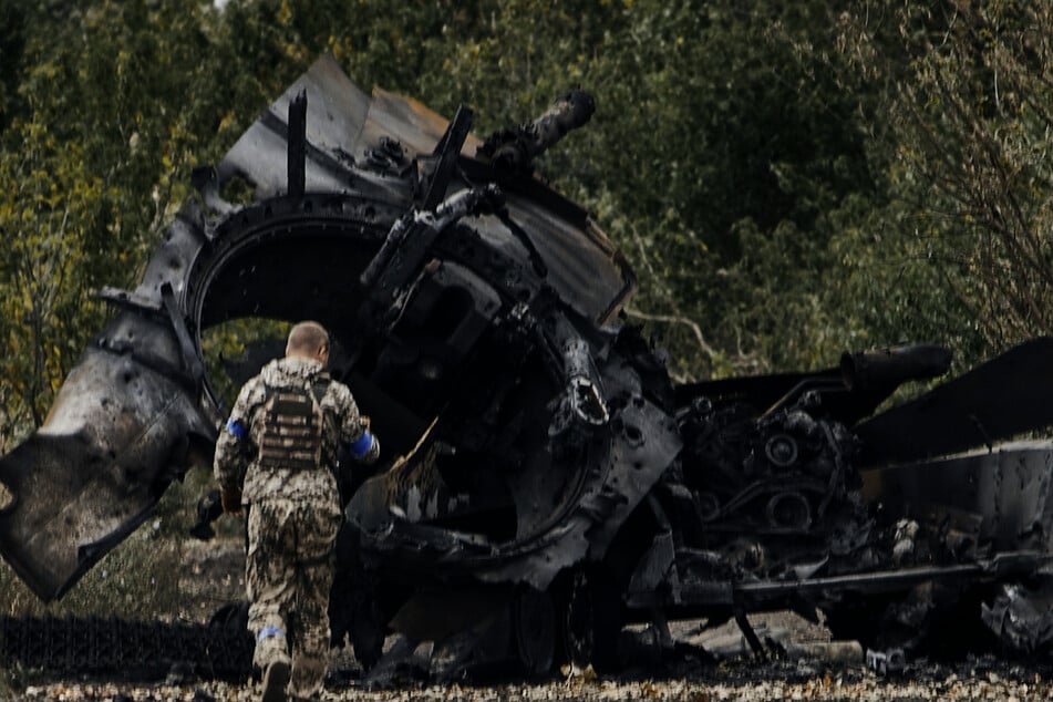 Ein ukrainischer Soldat in der Nähe eines russischen Panzers, der zerstört wurde.