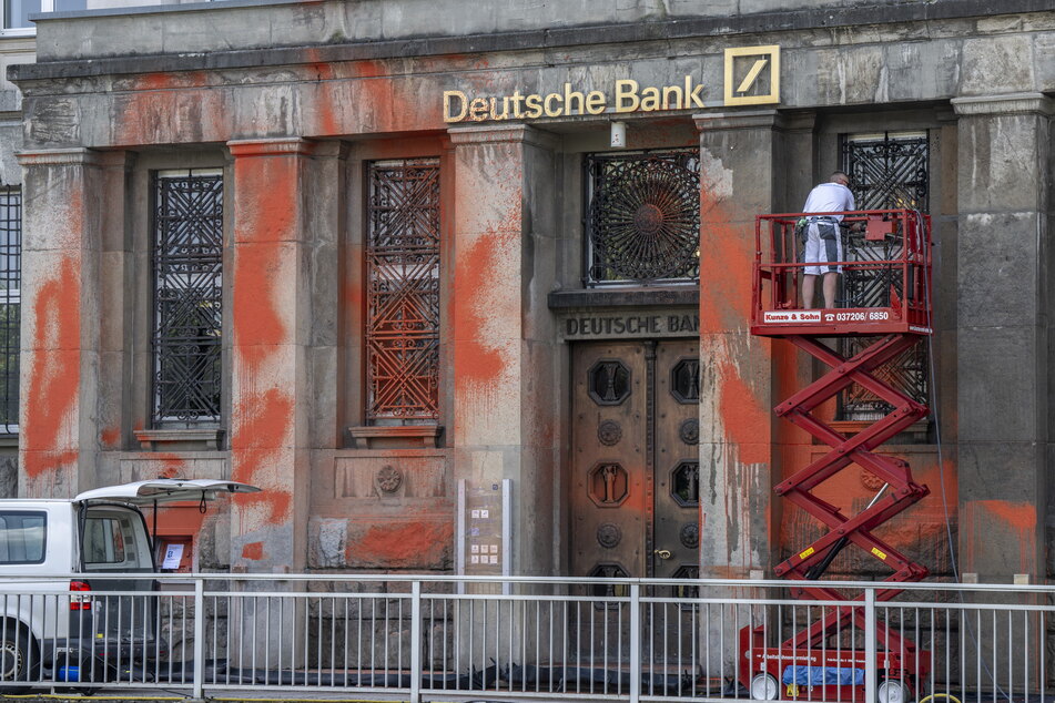 Die Farbe der "Letzten Generation" ist abwaschbar: Die Firma Heinrich Schmid reinigt die Fassade der Deutschen Bank.