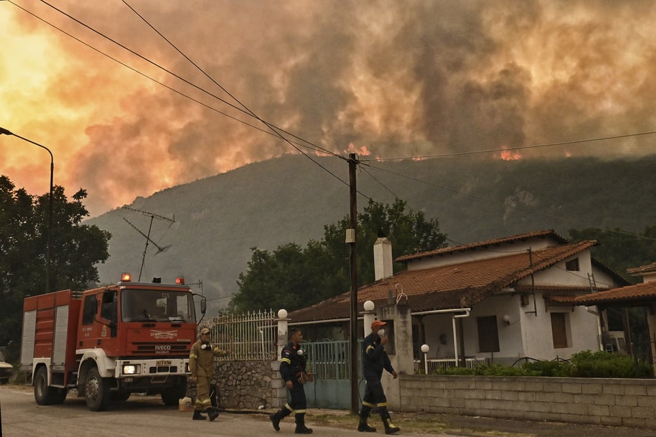 Feuerwehrleute bereiten sich auf Löscharbeiten eines Flächenbrandes westlich von Athen vor.