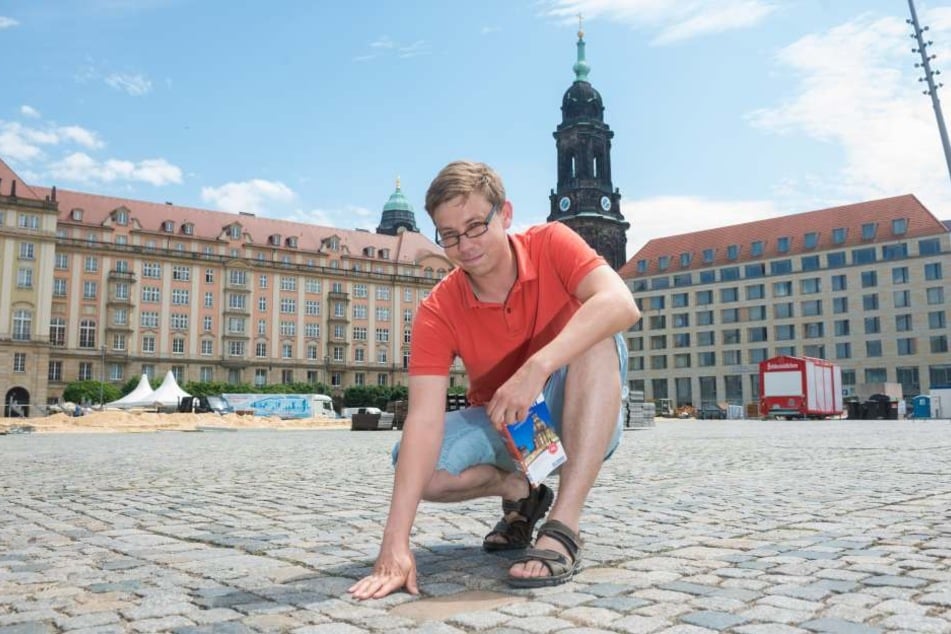 Wahl-Dresdner Andreas Rose (35) ist von der Geschichte der Stadt begeistert und
macht sich regelmäßig auf Spurensuche. Hier kniet er an der Stelle, an der einst
das alte Rathaus stand. Der Grundriss ist im Pflaster markiert.
