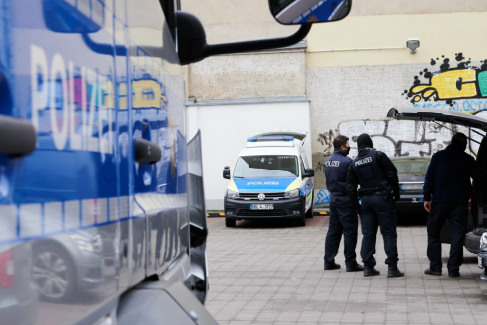 Ein Polizist steht bei einem Einsatz auf einem Parkplatz.
